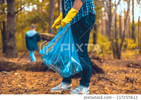 Mother and son eco activists collect garbage in the forest The family takes care of saving the forest from garbage. A woman teaches her child to take care of nature and clean up trash. Saving nature. Mother and son eco activists collect garbage in the forest The family takes care of saving the forest from garbage. A woman teaches her child to take care of nature and clean up trash. Saving nature. 117255612