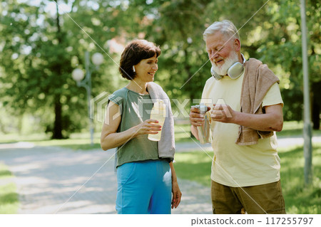 Sporty senior couple resting and drinking pure water after cardio train 117255797