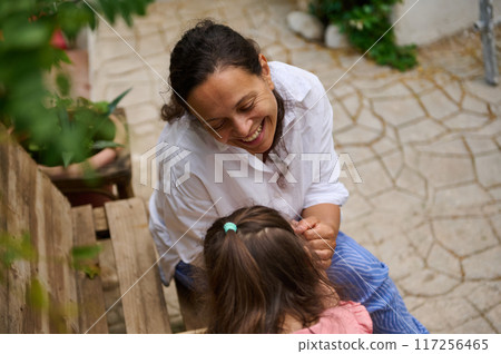 A mother and daughter spend quality time baking croissants together in a cozy kitchen. The little girl thoughtfully arranges baked goods while learning the art of cooking. A mother and daughter spend quality time baking croissants together in a cozy kitchen. The little girl thoughtfully arranges baked goods while learning the art of cooking. 117256465