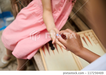 A mother and daughter spend quality time baking croissants together in a cozy kitchen. The little girl thoughtfully arranges baked goods while learning the art of cooking. A mother and daughter spend quality time baking croissants together in a cozy kitchen. The little girl thoughtfully arranges baked goods while learning the art of cooking. 117256489