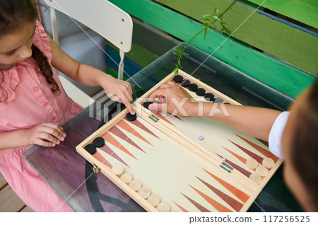 Family bonding fun playing backgammon together outdoors 117256525