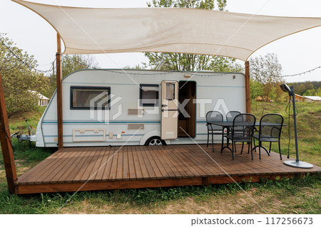 Caravan or camper trailer with Wooden Deck at Countryside Glamping Site. Outdoor Camping 117256673