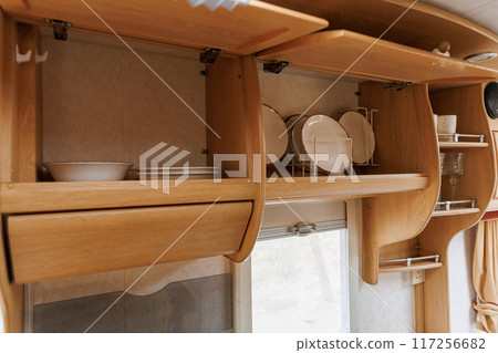 Cozy Caravan Interior with Kitchen and Sleeping Area. Ideal for Glamping, Camping, and Mobile Living 117256682