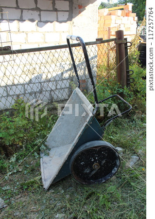 Construction Wheelbarrow on the grass. Use of construction equipment at the construction site 117257764