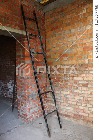 A black staircase leans against a brick wall. Construction Equipment A black staircase leans against a brick wall. Construction Equipment 117257769