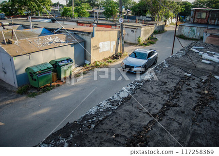 Large  of the garage complex, view from above.A silver Audi A7 is driving down the street of the garage complex. 117258369
