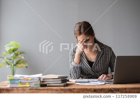 Young businesswoman has problems with her work in the office Feeling stressed and unhappy, showing a serious expression Young businesswoman has problems with her work in the office Feeling stressed and unhappy, showing a serious expression 117258909