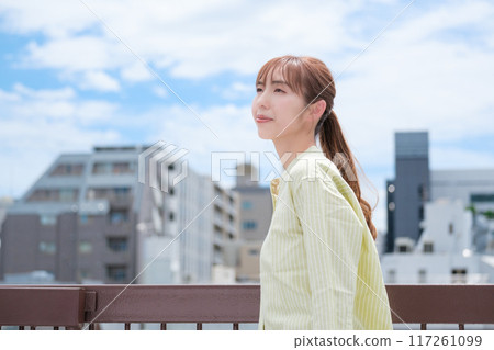 A young woman living her own life positively under the blue sky A young woman living her own life positively under the blue sky 117261099