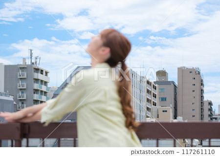 A young woman living her own life positively under the blue sky A young woman living her own life positively under the blue sky 117261110