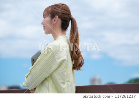 A young woman living her own life positively under the blue sky A young woman living her own life positively under the blue sky 117261237
