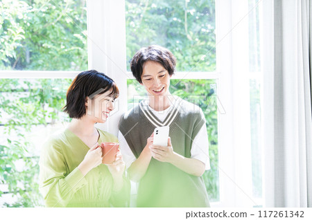 A young couple searching on a smartphone 117261342