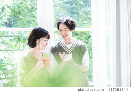 搜尋在智能手機的一對年輕夫婦 搜尋在智能手機的一對年輕夫婦 117261344