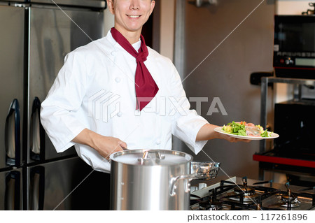 年輕的亞洲男廚師提供食物 年輕的亞洲男廚師提供食物 117261896