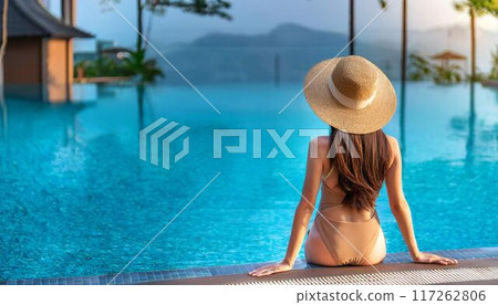 一個女人坐在游泳池旁 117262806