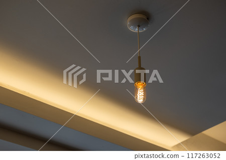 Hanging Edison light bulb, also known as filament light bulb. with ceiling cove lighting detail 117263052