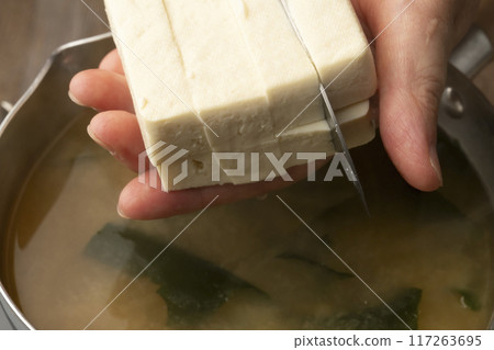 Make miso soup. Cut tofu. Add wakame seaweed. 117263695