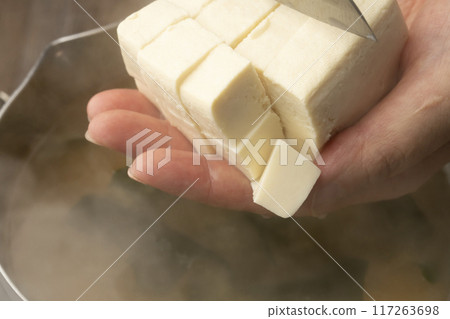 Make miso soup. Cut tofu. Add wakame seaweed. 117263698