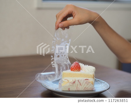 孩子的手從蛋糕上取下薄膜 117263851