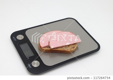 Sliced boiled delicious sausage on electronic scales, calorie counting, proper nutrition. 117264734