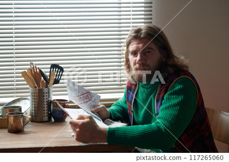 Reading Morning Newspaper Near Kitchen Window Reading Morning Newspaper Near Kitchen Window 117265060