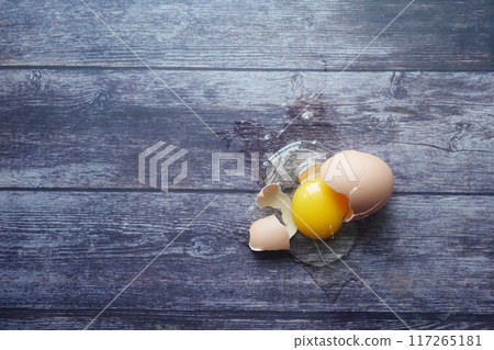 Fresh broken egg on wooden table  117265181
