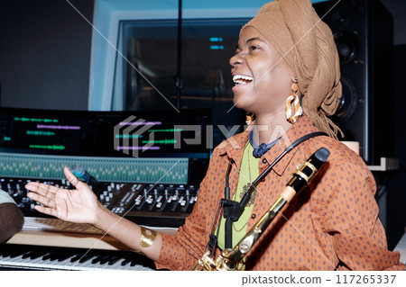 Laughing Musician Holding Saxophone During Recording Session 117265337