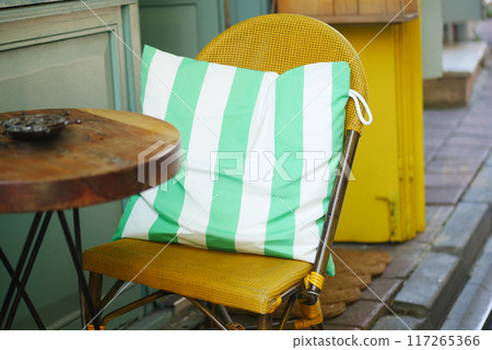 Stylish Chair with a Green Striped Cushion Set Beautifully in a Cozy, Inviting Setting Stylish Chair with a Green Striped Cushion Set Beautifully in a Cozy, Inviting Setting 117265366