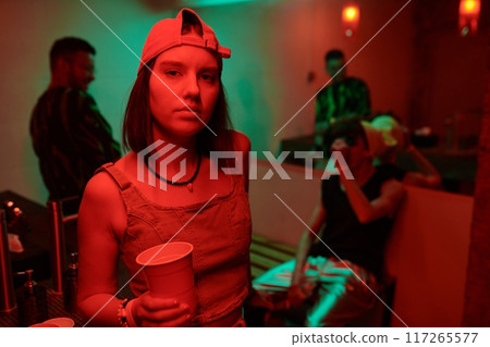 Neon lit young woman with cup of soda 117265577