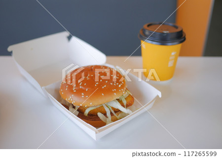 Enjoying a Delicious Burger and Coffee Presented Beautifully on a Minimalist Table Setting Enjoying a Delicious Burger and Coffee Presented Beautifully on a Minimalist Table Setting 117265599