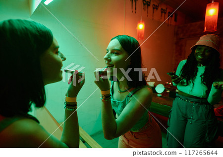 Happy glamorous girl applying lipstick 117265644