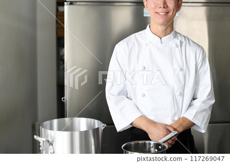 Young asian male chef preparing food in the kitchen Young asian male chef preparing food in the kitchen 117269047