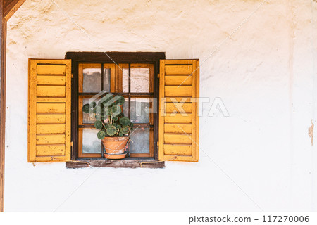 Old window with wooden frames, shutters and flowers. Old window with wooden frames, shutters and flowers. 117270006