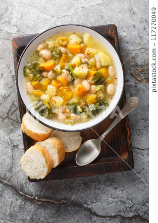 Zuppa Frantoiana Bean and Vegetable Soup closeup on the bowl. Vertical top view 117270049