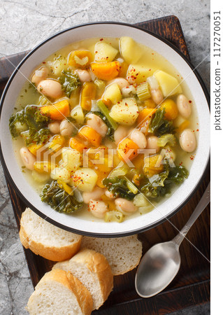 Zuppa Frantoiana italian bean soup with pumpkin and vegetables closeup on the bowl. Vertical top view 117270051