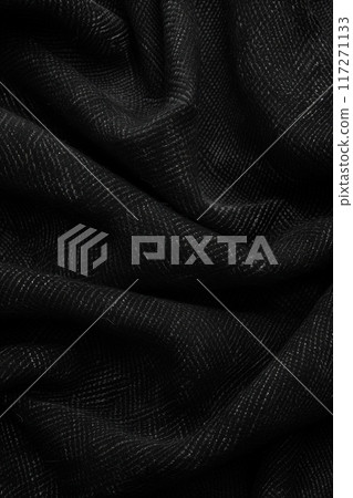 Close-up view of black fabric with zigzag pattern. Fabric has slightly wrinkled texture adding depth to scene. Gray stripe on right side creates contrast and visual interest. 117271133