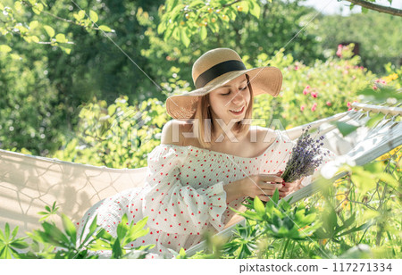 Young woman relaxing in a hammock Young woman relaxing in a hammock 117271334