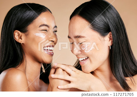 Happy, beauty and skincare women with cream for face isolated on a beige studio background. Wellness, smile and Asian model friends with sunscreen for love of cosmetics and dermatology on a backdrop Happy, beauty and skincare women with cream for face isolated on a beige studio background. Wellness, smile and Asian model friends with sunscreen for love of cosmetics and dermatology on a backdrop 117271705