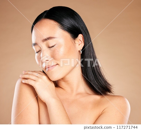 Asian woman, eyes closed and isolated for skincare, beauty or cosmetics against a brown studio background. Japanese female, person or lady model with smile in satisfaction for perfect gentle skin Asian woman, eyes closed and isolated for skincare, beauty or cosmetics against a brown studio background. Japanese female, person or lady model with smile in satisfaction for perfect gentle skin 117271744