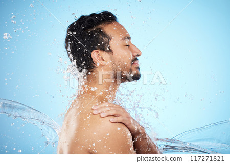 Man, water splash and clean for skincare, wellness and health with beauty, grooming and on blue studio background. Cleaning, male and shower for washing, organic care and hygiene for natural skin. Man, water splash and clean for skincare, wellness and health with beauty, grooming and on blue studio background. Cleaning, male and shower for washing, organic care and hygiene for natural skin. 117271821