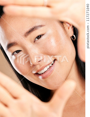 Studio portrait, hand frame and asian woman with smile for skincare, natural skin glow and wellness. Happy Japanese model, cosmetic beauty and healthy aesthetic with self care dermatology headshot 117271840