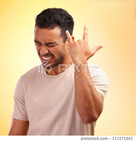 Happy, confident and Asian man with hand for rock isolated on a yellow studio background. Condidence, music and person with a gesture sign for fun, metal sound and audio on a bright backdrop 117271881