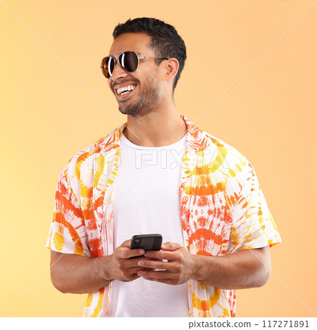 Sunglasses, phone and man typing in studio isolated on a yellow background. Technology, thinking and happy male model with mobile smartphone for social media, text messaging or internet browsing. 117271891