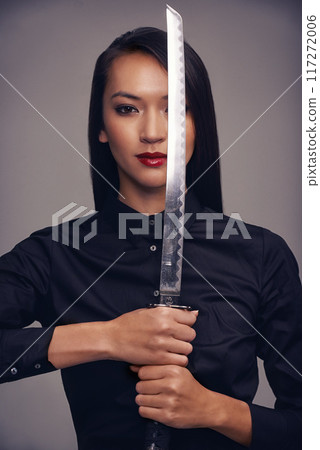 Portrait, ninja and sword with warrior woman in studio on a gray background for martial arts or combat. Training, fantasy and weapon with an asian samurai ready to defend using self discipline Portrait, ninja and sword with warrior woman in studio on a gray background for martial arts or combat. Training, fantasy and weapon with an asian samurai ready to defend using self discipline 117272006