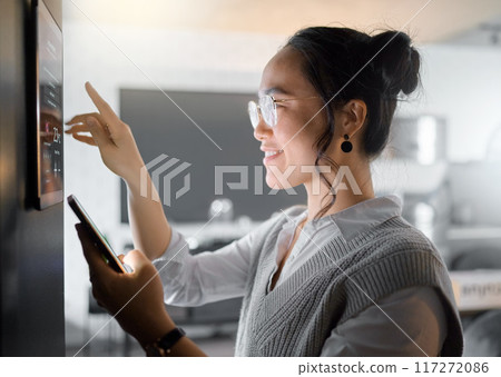 Smart home wall system, phone and woman with digital monitor for house automation, air conditioning or safety security network. App software, ui dashboard panel and Asian girl programming IOT tech 117272086