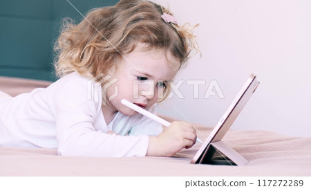 A little kid draws on the tablet computer with the stylus pen A little kid draws on the tablet computer with the stylus pen 117272289