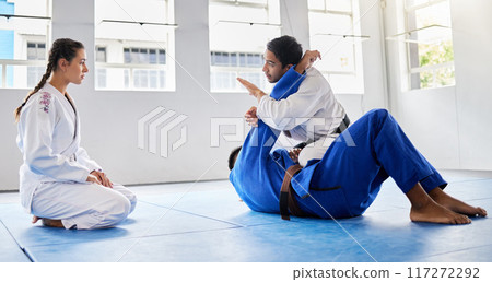 Karate, fitness and student learning from a teacher in a fighting workout, mma training or combat exercise. Sports, education and martial arts expert instructor coaching or teaching a girl or woman 117272292