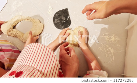 Little girl and her mom make heart shaped bread together at breadmaking masterclass. Love and care concept 117272293