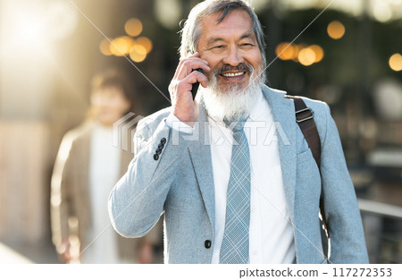 Travel, phone call and businessman walking in city bokeh with smile for career opportunity, communication or negotiation success. Urban, Asian and senior boss or leader talking on a mobile smartphone Travel, phone call and businessman walking in city bokeh with smile for career opportunity, communication or negotiation success. Urban, Asian and senior boss or leader talking on a mobile smartphone 117272353