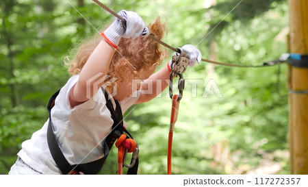 Little girl afraid of walking along outdoor climbing park trail in the forest. Fear of heights Little girl afraid of walking along outdoor climbing park trail in the forest. Fear of heights 117272357