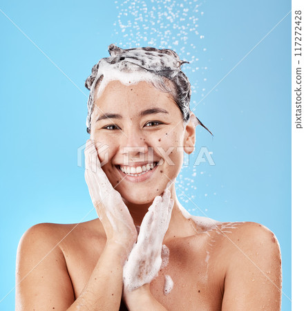 Woman, shower and for hygiene being clean and with smile for wellness against blue studio background. Portrait, water and Asian female or girl happy, with shampoo and skincare for health or body care Woman, shower and for hygiene being clean and with smile for wellness against blue studio background. Portrait, water and Asian female or girl happy, with shampoo and skincare for health or body care 117272428